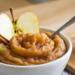 Fresh homemade apple puree in a bowl with garnishes