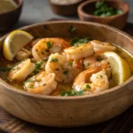 Slow cooker garlic butter shrimp in a rustic bowl with parsley and lemon.